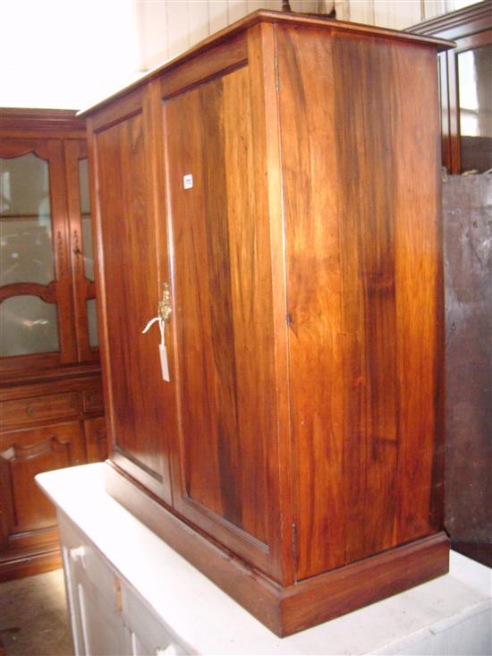 Walnut cupboard enclosed by a pair of panelled doors